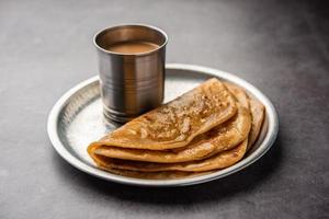 chai paratha: el té caliente servido con pan plano es una comida tradicional sencilla de india y pakistán foto