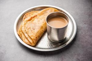 chai paratha: el té caliente servido con pan plano es una comida tradicional sencilla de india y pakistán foto