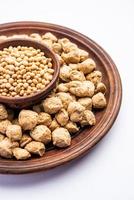 Glycine max or Soya bean or uncooked soybean chunks. Served in a bowl or as a Pile. selective focus photo