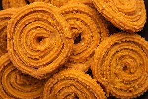 Chakli is a savoury snack from India. It is a spiral shaped snack with a spiked surface photo