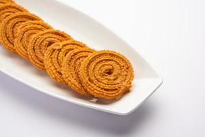 Chakli is a savoury snack from India. It is a spiral shaped snack with a spiked surface photo