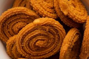 Chakli is a savoury snack from India. It is a spiral shaped snack with a spiked surface photo