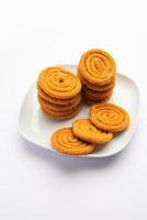 Chakli is a savoury snack from India. It is a spiral shaped snack with a spiked surface photo