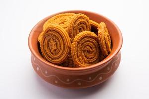 Chakli is a savoury snack from India. It is a spiral shaped snack with a spiked surface photo