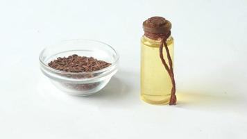 Isolated dish of flax seeds and small oil bottle video