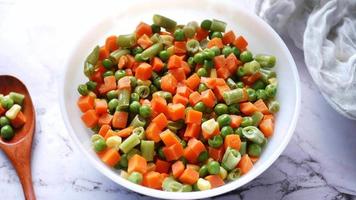 Bowl of carrots peas and green beans in bowl video