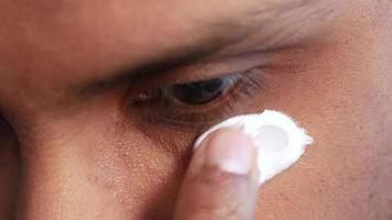 close-up de homem aplicando sob creme para os olhos video