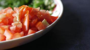 Close up of bowl with chopped tomatoes sliced lime and other ingredients video