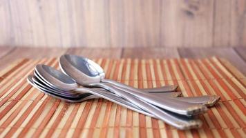 A pile of silver spoons on wooden surface video