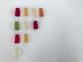 gummy bears lie on a white matte background. gummy bears are arranged by color. bright multicolored candy in the shape of a flag. handmade dessert. decorating cakes and pastries photo