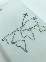 white matte phone case with world map. the plane flies to another continent. black thick lines on the material. rubber texture, smooth homogeneous structure photo