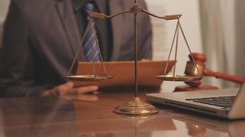 Business and lawyers discussing contract papers with brass scale on desk in office. Law, legal services, advice, justice and law concept video