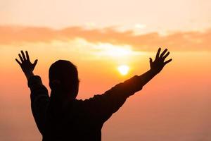 Silhouette of woman hand praying spirituality and religion, female worship to god. Christianity religion concept. Religious people are humble to God. Christians have hope faith and faith in god. photo