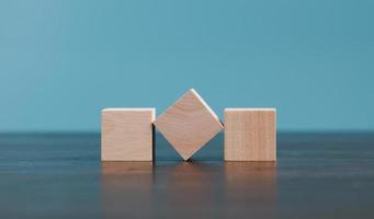 Stacking blank wooden cubes on blue background with copy space for input wording and infographic icon. Empty brown wooden object block for symbol icon put technology, zero gravity, business concept. photo