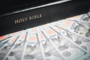 One tenth or tithe is basis on which Bible teaches us to give one tenth of first fruit to God. coins with Holy Bible. Biblical concept of Christian offering, generosity, and giving tithes in church. photo