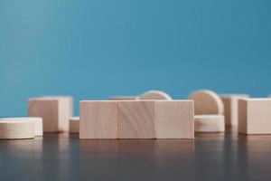 Stacking blank wooden cubes on blue background with copy space for input wording and infographic icon. Empty brown wooden object block for symbol icon put technology, zero gravity, business concept. photo