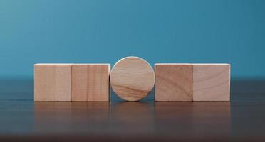 Stacking blank wooden cubes on blue background with copy space for input wording and infographic icon. Empty brown wooden object block for symbol icon put technology, zero gravity, business concept. photo