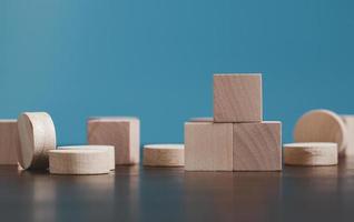 Stacking blank wooden cubes on blue background with copy space for input wording and infographic icon. Empty brown wooden object block for symbol icon put technology, zero gravity, business concept. photo