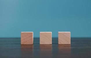 Stacking blank wooden cubes on blue background with copy space for input wording and infographic icon. Empty brown wooden object block for symbol icon put technology, zero gravity, business concept. photo