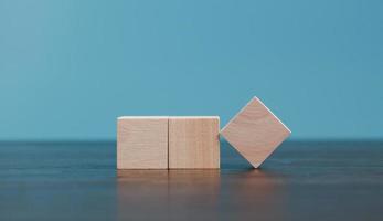 Stacking blank wooden cubes on blue background with copy space for input wording and infographic icon. Empty brown wooden object block for symbol icon put technology, zero gravity, business concept. photo