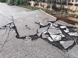 decayed road paved asphalt distressed road surface with damaged, peeling damaged road waiting for road repair roadway photo