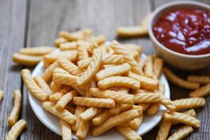 crunchy prawn crackers or shrimp crisp traditional snack - prawn crackers stick on plate and ketchup photo