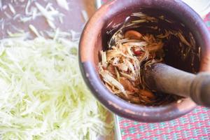 Papaya Salad Thai Food Style Asian - cooked green papaya shredded with ingredient herbs and spices in mortar photo