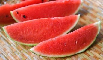 close up fresh watermelon pieces tropical summer fruit - watermelon slice on wood background photo