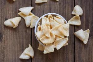 crunchy prawn crackers or shrimp crisp rice for traditional snack - prawn crackers chips on bowl and wooden table background , top view photo