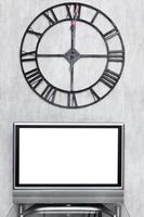 wall clock under blank white screen of TV set photo