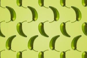 Pattern of green peppers isolated on light green background. Creative photo of peppers aligned with copy space.