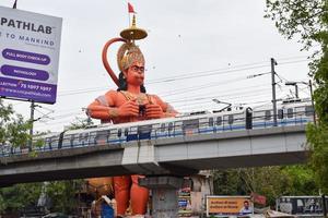 New Delhi, India - June 21, 2022 - Big statue of Lord Hanuman near the delhi metro bridge situated near Karol Bagh, Delhi, India, Lord Hanuman big statue touching sky photo