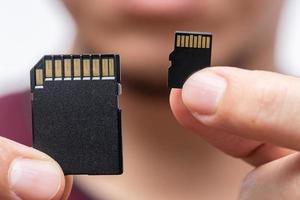 El tamaño de la memoria de almacenamiento digital importa el concepto, la tarjeta sd y la tarjeta micro sd se comparan en el mango foto