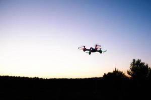 helicóptero quad drone de juguete contra el cielo del atardecer foto