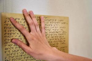 Woman reading braille text on braille plate