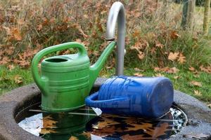 Two watering can in garden photo
