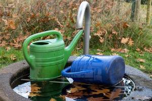 Two watering can in garden photo