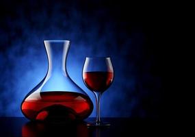 Carafe and Red Wine Glass with Textured Blue Background - 3D Illustration photo