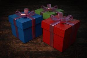 tres cajas de regalo de colores con lazos en una mesa de madera. foto