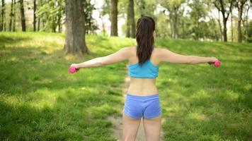 mujer haciendo ejercicios con pesas en el parque video