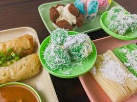 bocadillos tradicionales de Indonesia. klepon es una comida tradicional que tiene un sabor dulce con salsa de azúcar moreno y salado con una pizca de coco rallado foto