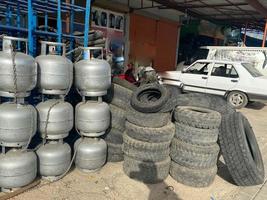 Iron metal cylinders for storing liquefied gas for cooking and industrial stand in a row with a wall in an industrial warehouse photo