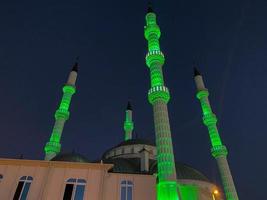 Large beautiful high muslim mosque islamic temple for prayers to god allah with high religion towers in warm tropical eastern country southern resort at night photo