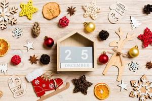 Top view of calendar on Christmas wooden background. The twenty fifth of December. New Year toys and decorations. Holiday concept photo