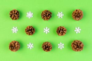 Top view of New Year ornament made of white snowflakes and pine cones on colorful background. Winter holiday concept with empty space for your design photo