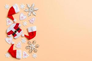 Top view of Christmas decorations and Santa hats on orange background. Happy holiday concept with copy space photo