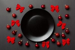 Top view of holiday dinner on colorful background. Plate, baubles and bows. Christmas Eve concept photo