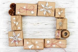 New Year and Christmas Frame Composition. handmade wrapped christmas gift boxes with decoration on white background with empty copy space for your text. above view, flat lay photo