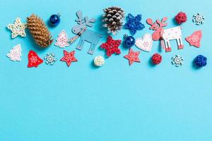 Top view of New Year toys and decorations on blue background. Christmas time concept with empty space for your design photo