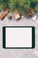 Digital tablet mock up with rustic Christmas gray cement background decorations for app presentation. top view with copy space. Toned photo